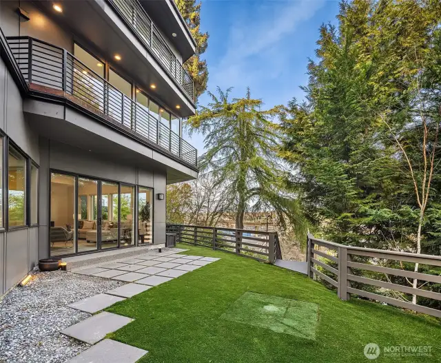 Turfed, spacious backyard. Walk around the side of the home for the sauna and kayak storage.