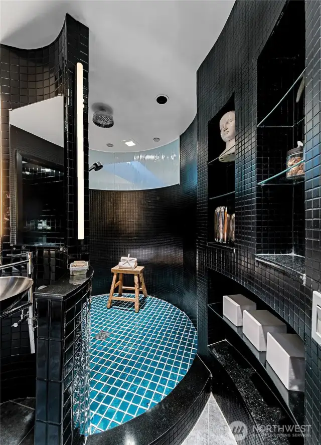 A curved wall and mosaic tile frames this elegant bathroom.