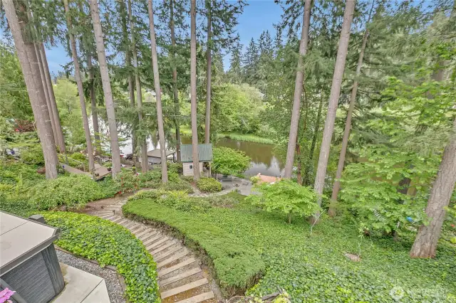 The back of the property with a lighted stairway that leads to the dock and waterfront patio.