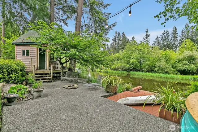 Waterfront patio and dock with cabin-style retreat.