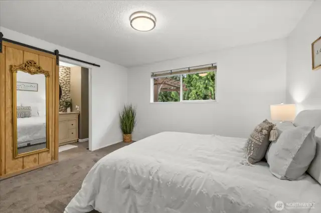 Barn door opens to the primary bathroom.