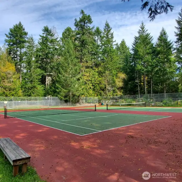 Double tennis courts outside clubhouse w/sport court beyond and community gardens to right.  We play pickle ball here!