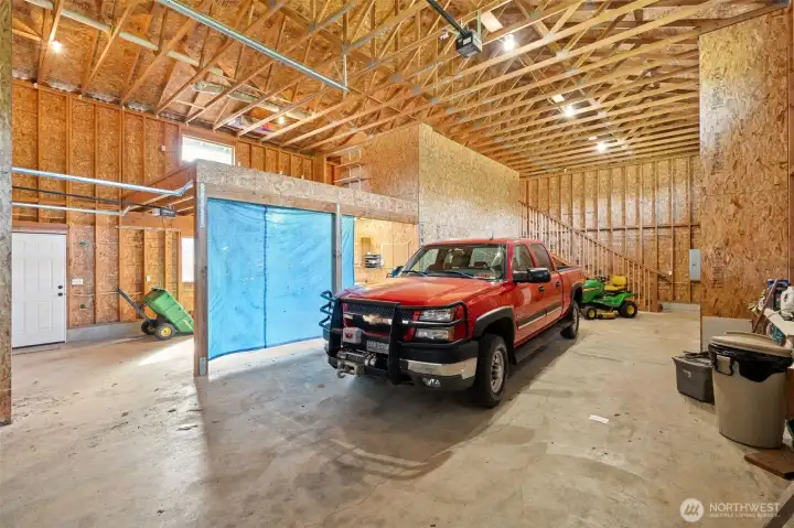 Stairwell leads to loft space above. Large workbench area behind tarp