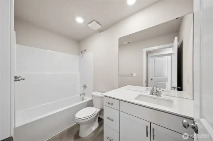 Bright and functional upstairs bathroom featuring a clean tub/shower combo, quartz vanity, and modern lighting.  Pictures are for representational purposes only, colors and features may vary.