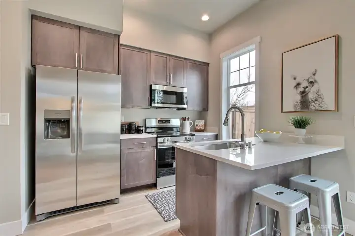 **Photos are of Unit B, for illustrative purposes only. Unit C has all the same finishes w/reversed floor plan.** Fully-applianced kitchen featuring stainless steel appliances, quartz countertops & soft close cabinets.