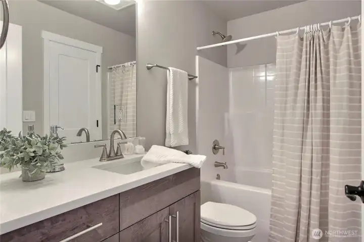 **Photos are of Unit B, for illustrative purposes only. Unit C has all the same finishes w/reversed floor plan.** Full bathroom with quartz countertops.