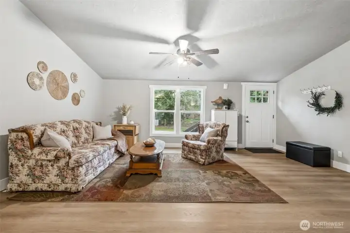 The bright living room offers a welcoming space for everyday relaxation. Large windows bring in natural light and highlight the peaceful surroundings. It’s a comfortable place to unwind.