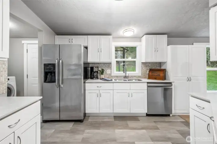 The remodeled kitchen features quartz countertops and a stylish tile backsplash. Modern finishes elevate the space while maintaining a warm, welcoming feel. It’s a kitchen designed for both beauty and function.