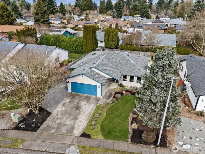 This aerial angle tells a very practical love story. A flat, approachable lot means smoother arrivals, easier parking, and one less thing to stress about when the weather decides to get dramatic. You can really see how nicely maintained everything is, from the crisp exterior paint to the tidy layout of the property. It feels organized, comfortable, and ready for real life, whether that means guests pulling in for a visit or just your own daily routine flowing a little more effortlessly.