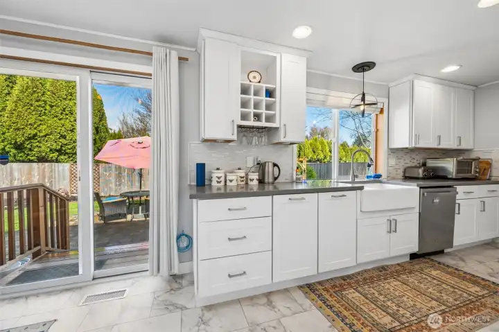 This angle shows off one of the home’s best personality traits, the flow. Warm engineered hardwood carries your eye from the kitchen through the dining room and back toward the front entry, where a large coat closet and bonus drop spot keep the everyday mess politely out of sight. The huge dining room window pulls in light and adds a sense of openness that makes the whole main living area feel bigger than expected.
