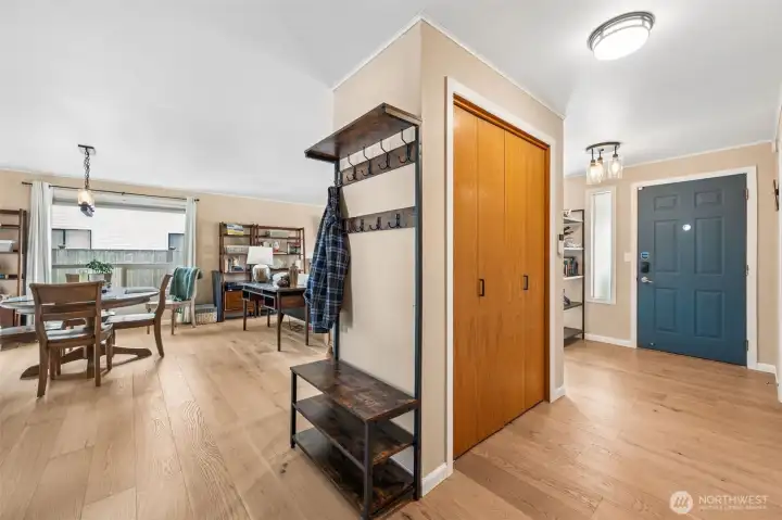 This angle shows off one of the home’s best personality traits, the flow. Warm engineered hardwood carries your eye from the kitchen through the dining room and back toward the front entry, where a large coat closet and bonus drop spot keep the everyday mess politely out of sight. The huge dining room window pulls in light and adds a sense of openness that makes the whole main living area feel bigger than expected.
