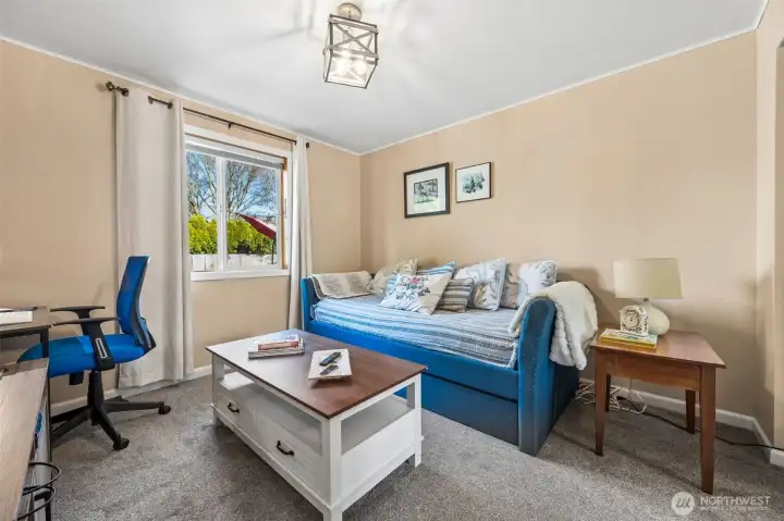 Currently styled as that very real life combo of workspace meets guest retreat, this third bedroom shows off its flexibility in a very relatable way. Natural light from the backyard window keeps the room feeling open and pleasant during work hours, then cozy enough to wind down when the laptop closes. Warm latte paint, neutral carpeting, and a clean lined modern fixture create a simple backdrop that plays well with whatever direction you want to take it, home office, hobby zone, or a comfortable bedroom for whoever moves in next.