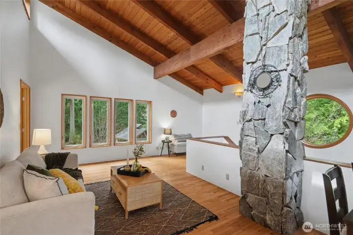 Natural light pours in, illuminating the hardwood floors and creating a warm, inviting atmosphere that seamlessly connects to the dining area and kitchen.