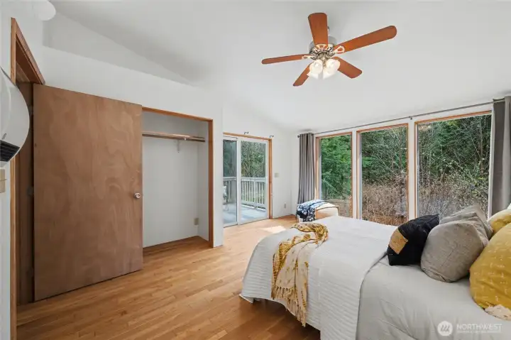 Sliding glass doors provide direct access to outdoor spaces, enhancing the sense of retreat. Light wood flooring and simple finishes keep the focus on the natural beauty just beyond the glass.