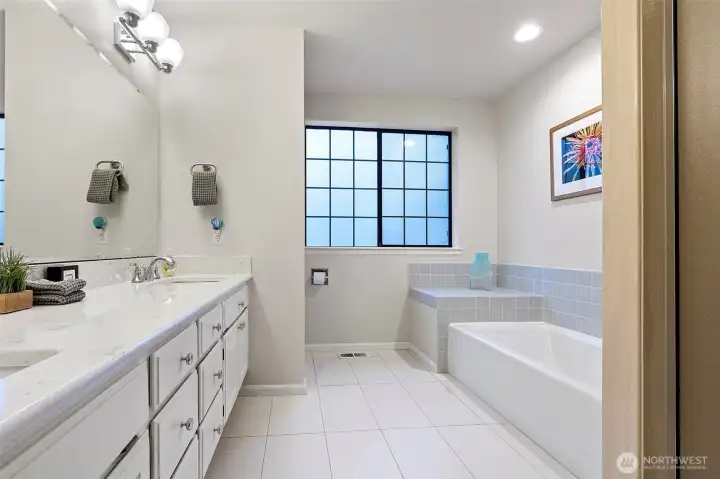 Full bathroom upstairs with separate tub and shower and dual sink vanity