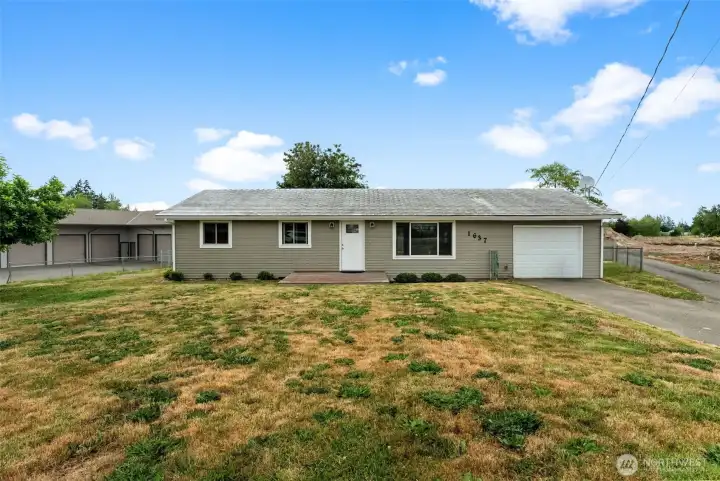 Front exterior highlights the home's spacious setting with an expansive yard and convenient driveway access.