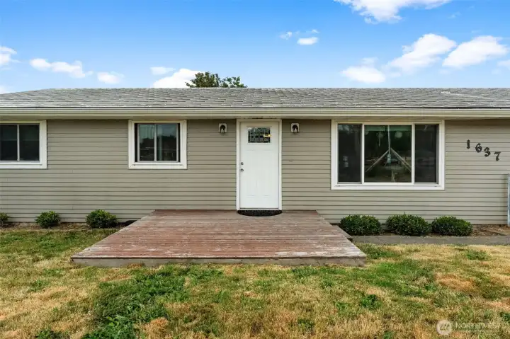 Front exterior highlights the home's spacious setting with an expansive yard and convenient driveway access.