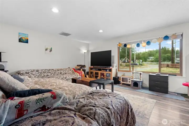 Large front-facing window and open floor plan create a comfortable, versatile living space.