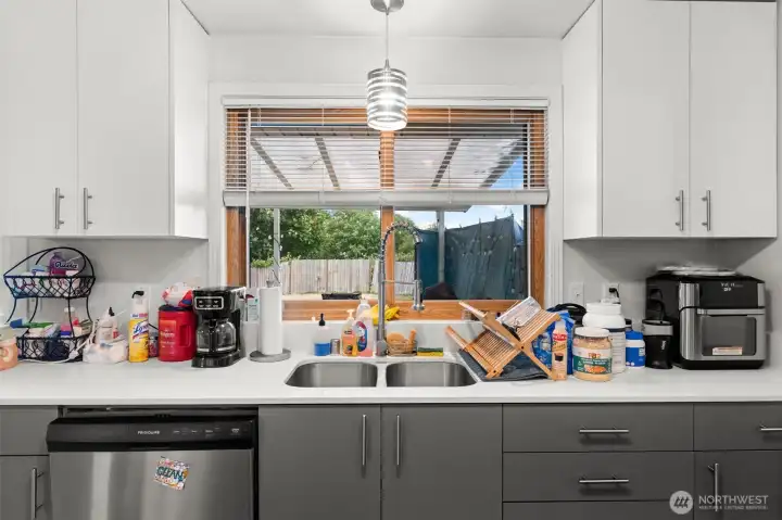 Alternate kitchen view highlights the sink area, extensive cabinetry, and generous countertop workspace.