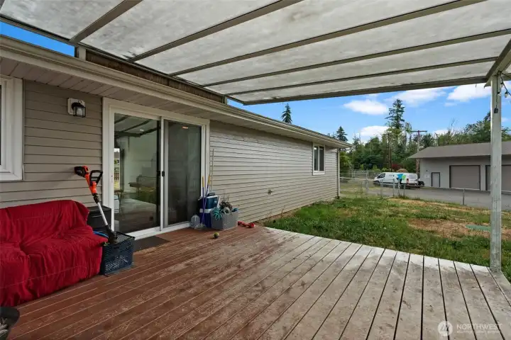 Alternate view of the covered patio highlights seamless indoor-outdoor access and backyard connection.