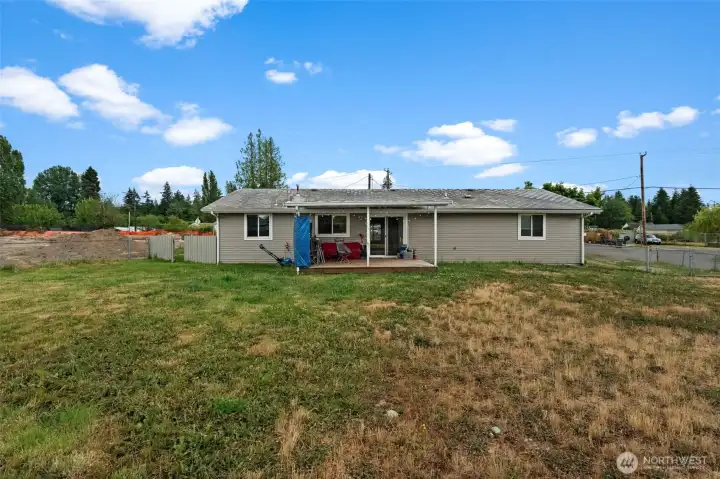 Backyard offers a generous lawn with a covered patio for outdoor enjoyment.