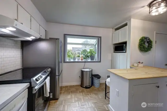 Open design kitchen with breakfast nook. Notice the bay window that works as a greenhouse