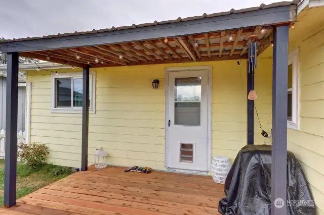 Covered rear deck and fully fenced back yard. The doorway goes into the utility/laundry room and pantry.