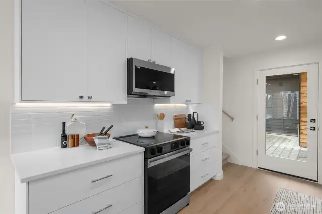 Crisp white cabinetry, quartz countertops, and integrated appliances set the tone for a kitchen that works as hard as you do—while still looking good doing it.