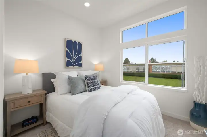 Photos of model home with similar finishes & floor plan. This sunlit bedroom is your peaceful retreat, with large windows that frame green views and fill the room with calming light—morning person or not, you’ll love waking up here.