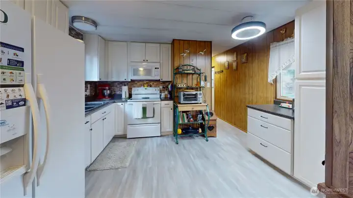 The kitchen features plenty of cabinet and counter space, flat top range, double door refrigerator, display hutch, ceiling fan and so much more!