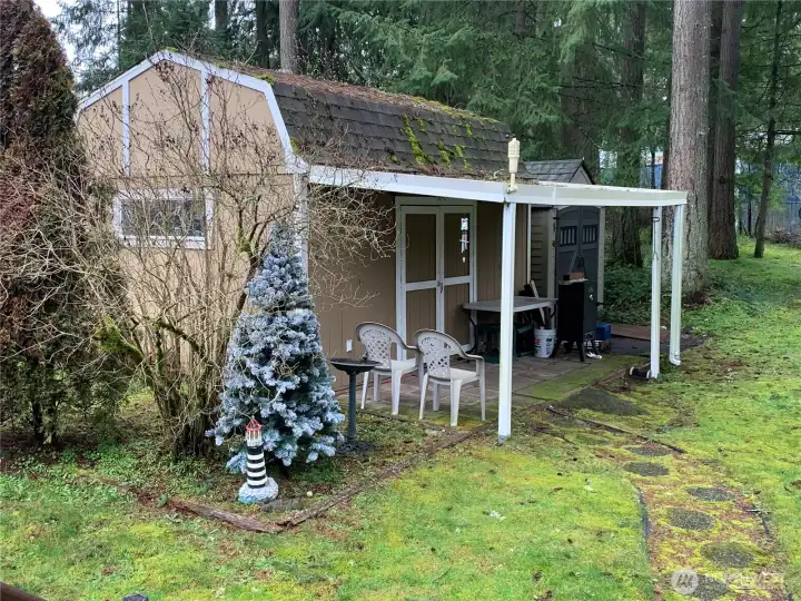 Large shed with tons of storage, covered front patio and work bench!