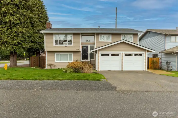 Front view of home with newer siding, trim and paint. 2 car garage. Corner lot.