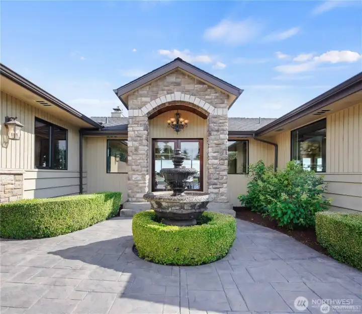 Welcome home to a tranquil entrance featuring a charming fountain that sets the tone for peaceful living