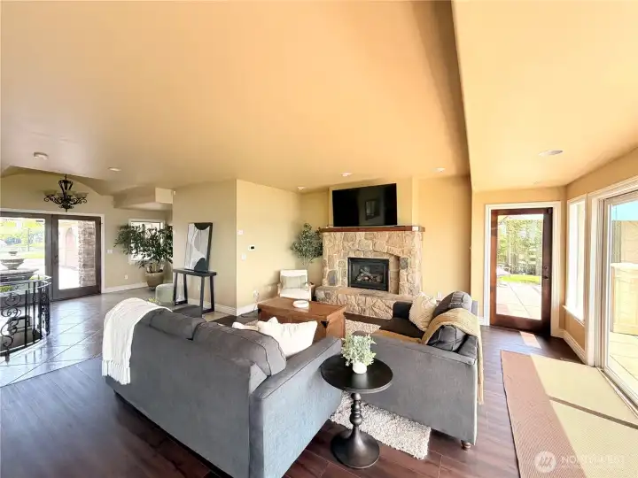 Open concept living area featuring a stunning rock fireplace and massive sliding doors that seamlessly open to the deck—perfect for entertaining and enjoying indoor-outdoor living.