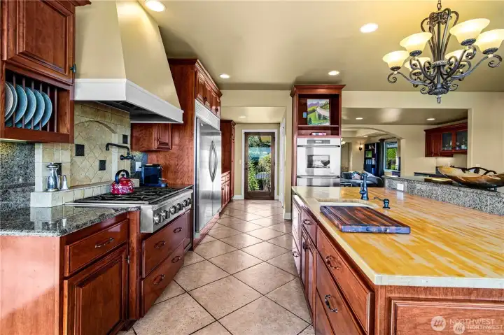 Chef’s dream kitchen boasts a spacious butcher block countertop paired with panoramic views—ideal for both culinary creativity and entertaining.