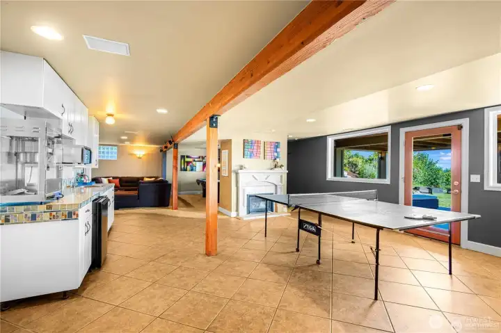 Lower level designed for fun and relaxation, featuring pool and ping pong tables alongside a built-in TV area—perfect for game nights and movie marathons.