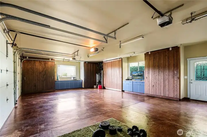 Three-car garage equipped with extensive shelving, rolling doors for flexibility, and sleek epoxy flooring for a clean, polished look
