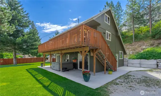 Exterior view of grassy lawn, private hot tub & grassy landscaped yard.
