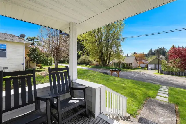Beautiful front porch with space for rocking chairs and a wonderful view of the mountains and manicured front yard.