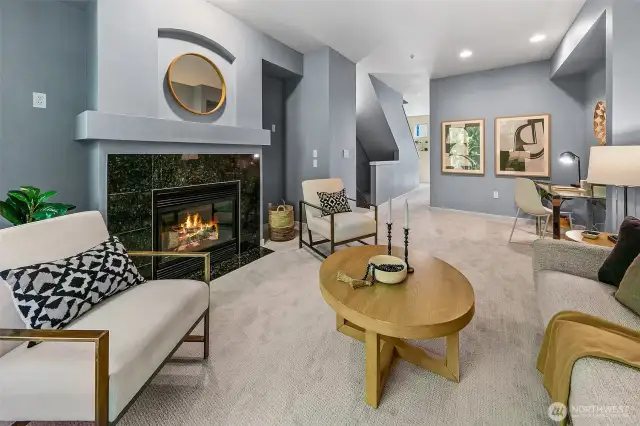 Anchored by a fireplace, the living room also has high ceilings and fresh paint and carpets.