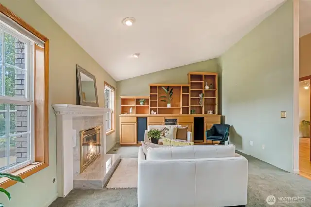 Vaulted ceilings add dimension and airiness, while a wall of custom built-in cabinetry offers abundant storage and display space, perfect for showcasing art, books, or entertaining essentials.