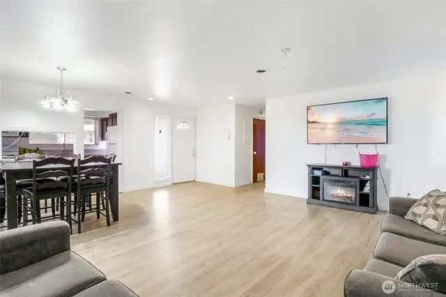 From this view, you can see the front door with a window at the top of it, the kitchen to the left, and the hallway to the bedrooms.