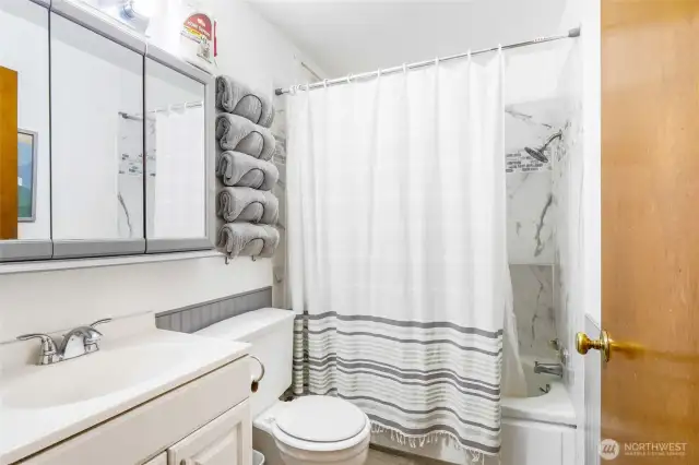 The main bathroom is in the hallway and has an updated tub and shower combo, with light grey chair-rail distinctions.