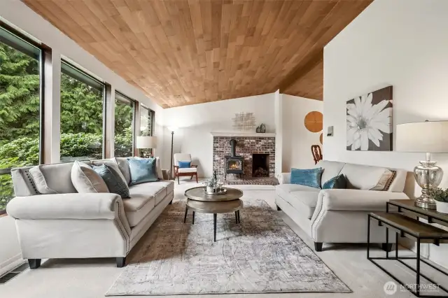 The wood-paneled vaulted ceilings and brick fireplace with cozy wood stove put off tones of "cabin relaxation".