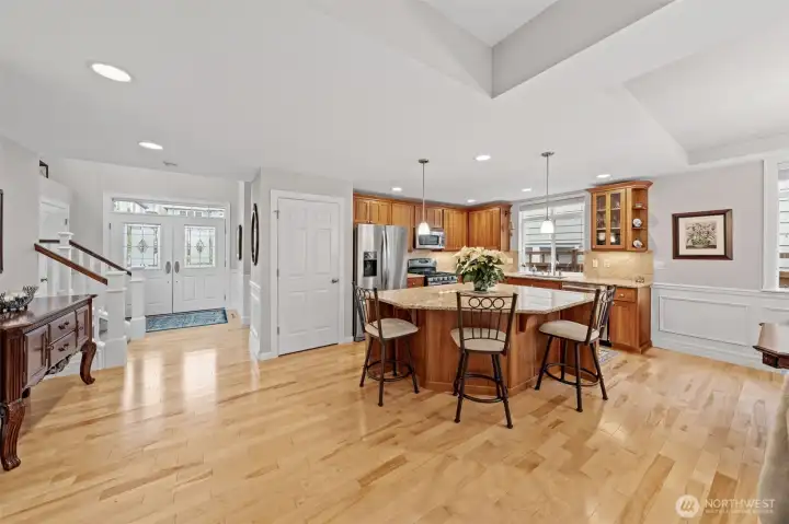The open layout highlights the Birch hardwood floors and guides you seamlessly from the foyer into the heart of the home. The kitchen impresses with Shaker cherry cabinets, granite counters, a large island, and pendant lighting on a dimmer, creating an inviting space for gatherings.
