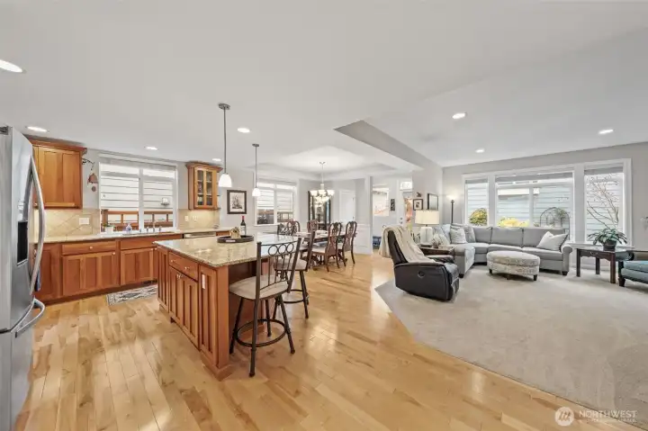 The kitchen, dining, and living areas flow together effortlessly, creating an open and connected layout ideal for gatherings and everyday living. Box-recessed ceilings and abundant natural light elevate the space, adding architectural interest while unifying the entire room with a bright, inviting feel.