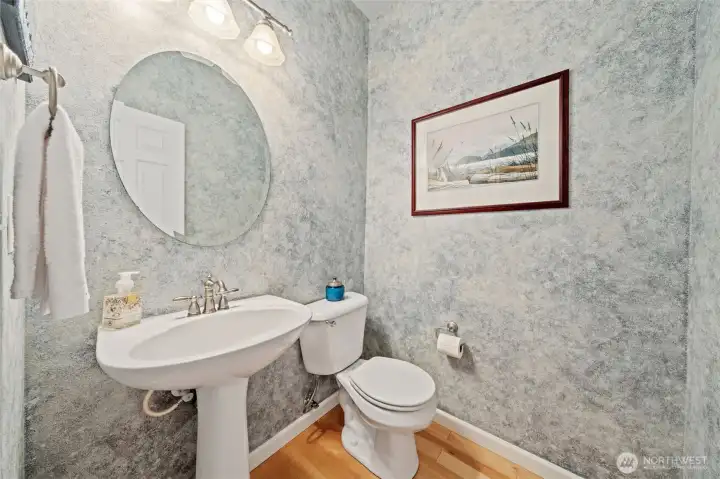 The powder room features a faux-finish wall treatment that adds texture and visual interest, giving the space a refined, custom feel. A pedestal sink, updated fixtures, and soft lighting complete this welcoming and stylish main-level bath.