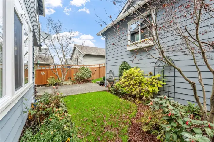 The backyard offers a peaceful outdoor retreat with thoughtful landscaping and a charming mix of greenery. The space is fully fenced, providing privacy and a secure setting for relaxing, gardening, or enjoying time outdoors.