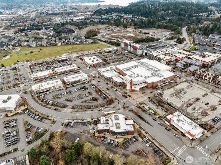 An expansive aerial view of the Issaquah Highlands commercial district, showcasing a wide variety of shops, dining options, services, and entertainment