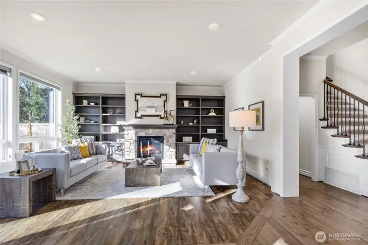 Living room with built in shelves and cozy gas fireplace.